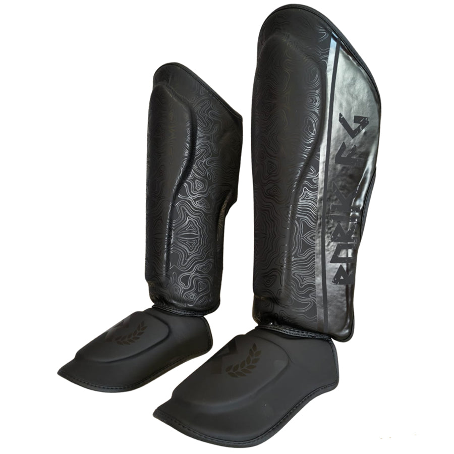Rurik Fightgear Grimnir säärisuojat on suunniteltu thainyrkkeilyyn ja potkunyrkkeilyyn. Ergonominen muotoilu, tehokas iskunvaimennus ja kestävät kiinnitykset. kuvassa sääritukipari viistosti. 