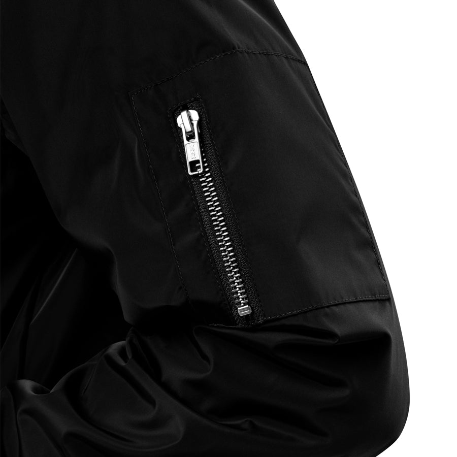 Rurik Fightgear-lentäjänpusakka.
Rurik FG "R" -logo rintapielessä sekä riimulogo selässä monivärisesti brodeerattuna. Kuvassa hihan yksityiskohta. ptcombet.com