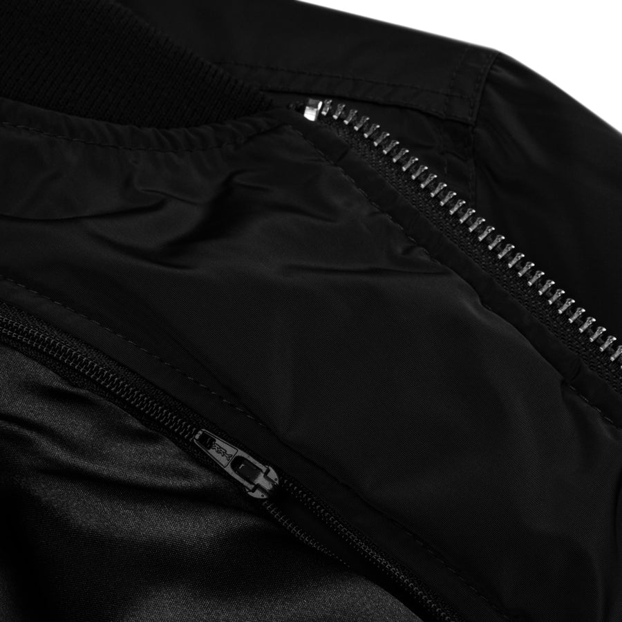 Rurik Fightgear-lentäjänpusakka.
Rurik FG "R" -logo rintapielessä sekä riimulogo selässä monivärisesti brodeerattuna. Kuvassa takin yksityiskohta. ptcombet.com