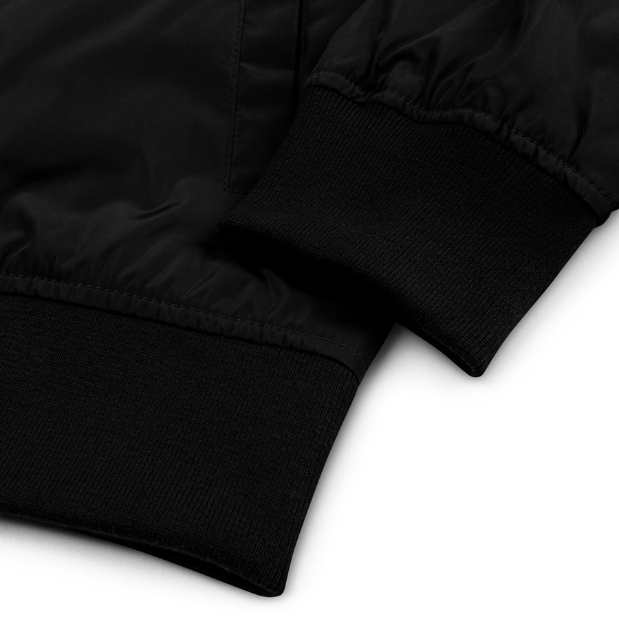 Rurik Fightgear-lentäjänpusakka.
Rurik FG "R" -logo rintapielessä sekä riimulogo selässä monivärisesti brodeerattuna. Kuvassa pilottitakin resorit. ptcombet.com