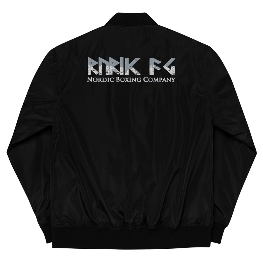 Rurik Fightgear-lentäjänpusakka.
Rurik FG "R" -logo rintapielessä sekä riimulogo selässä monivärisesti brodeerattuna. Kuvassa pilottitakki  takaa. ptcombet.com