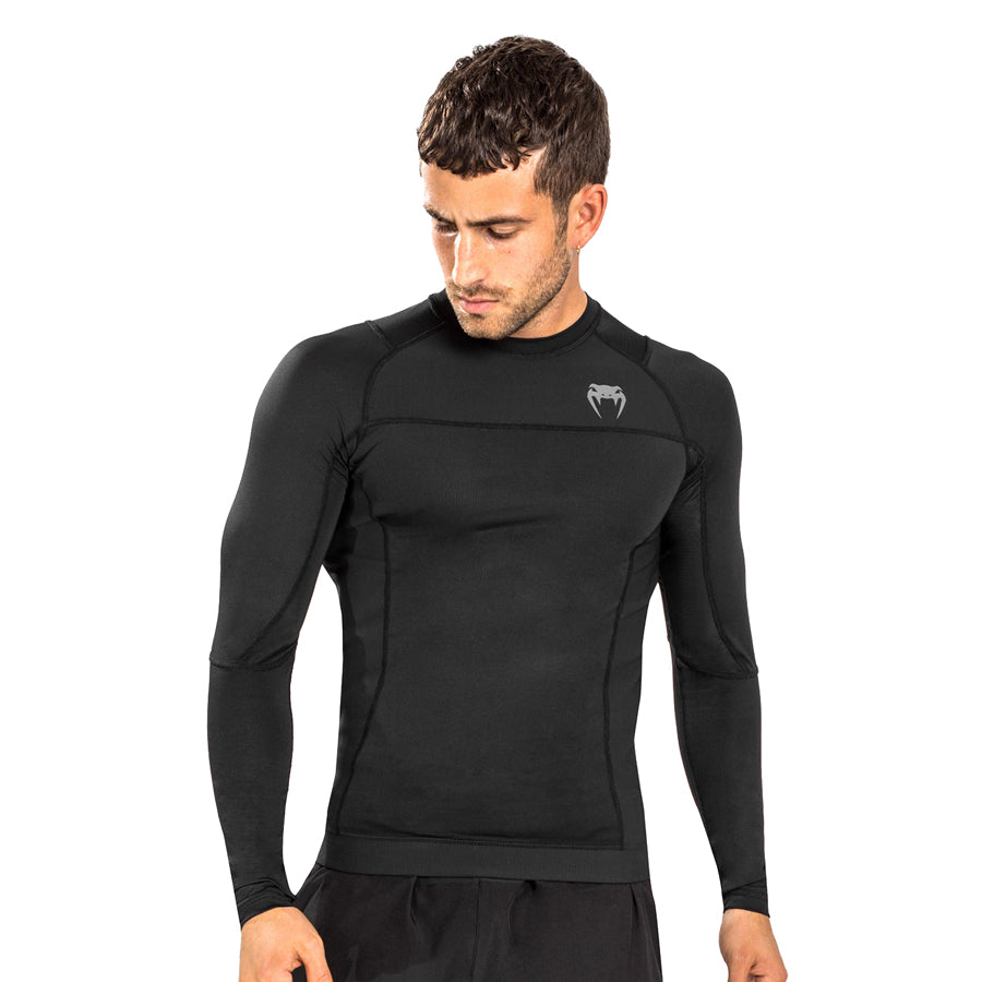 Venum G-Fit Air Long-Sleeve Rashguard. Paidassa on venumin logo vasemmassa rinnassa. Kuvassa rashguard kuvattuna miehen päällä. ptcombet.com