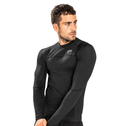 Venum G-Fit Air Long-Sleeve Rashguard. Tyylilkäs musta väri. Kuvassa rashguard kuvattuna viistosti miehen päällä. ptcombet.com