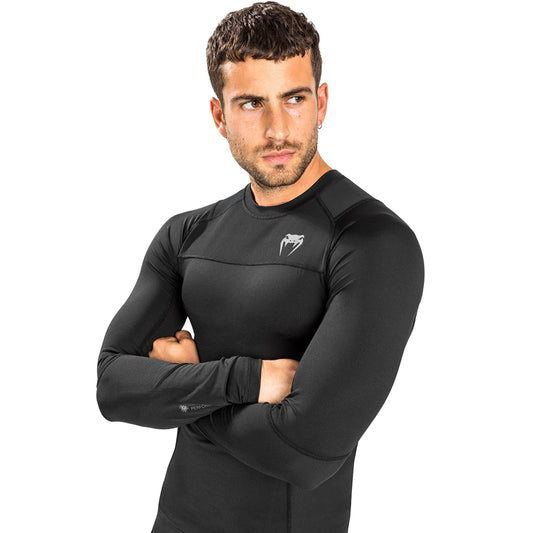 Venum G-Fit Air Long-Sleeve Rashguard. Tyylilkäs musta väri. Kuvassa rashguard kuvattuna miehen päällä. ptcombet.com